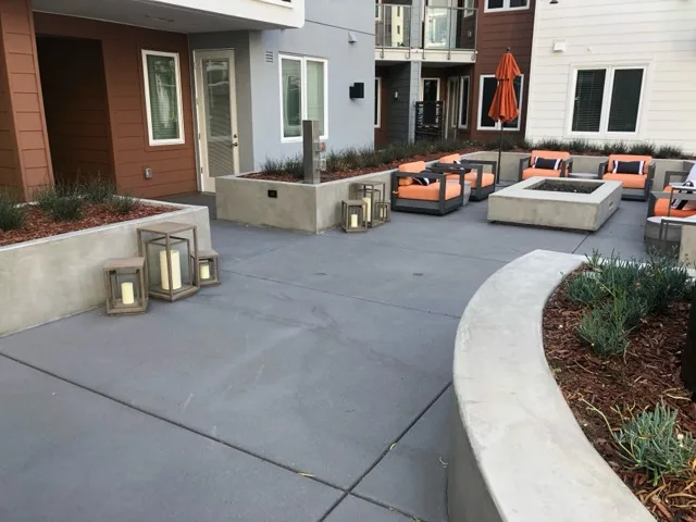 Concrete courtyard with fire pit and planters